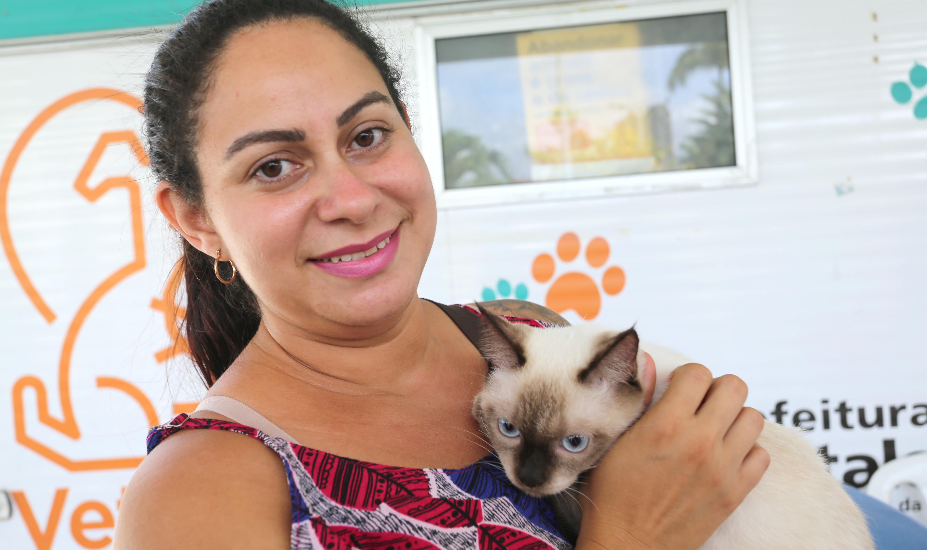 mulher sorrindo segurando gato e sorrindo para a foto